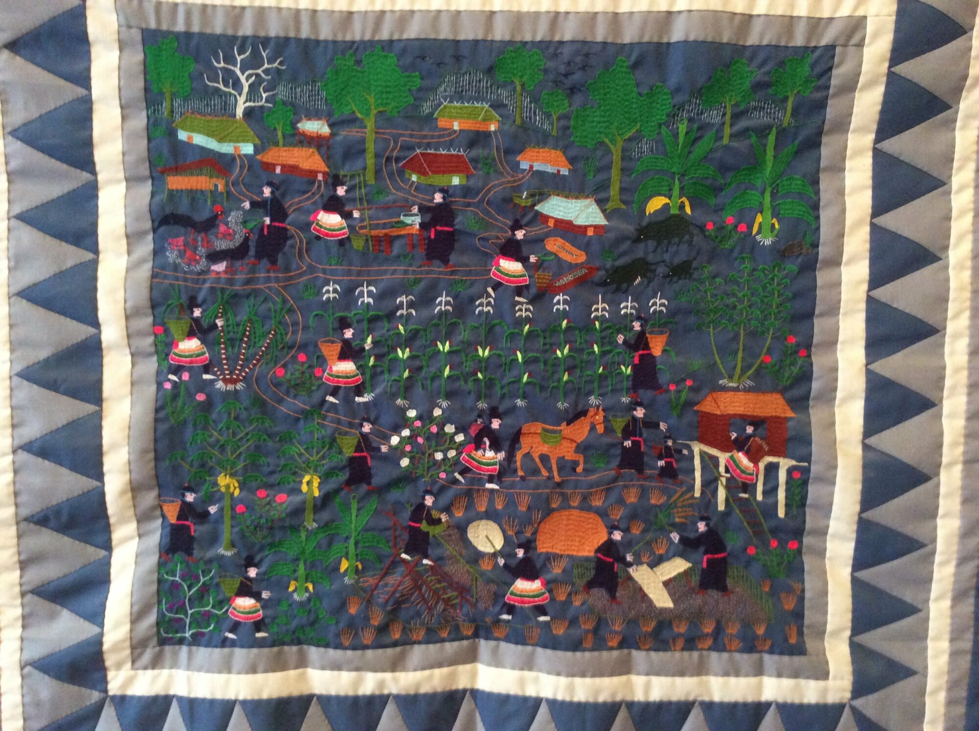 Hmong tapestry depicting farming in the homeland